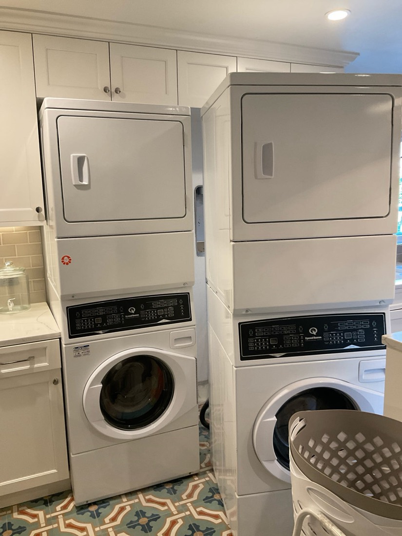 Stacked commercial-grade washer and dryer in finished laundry room