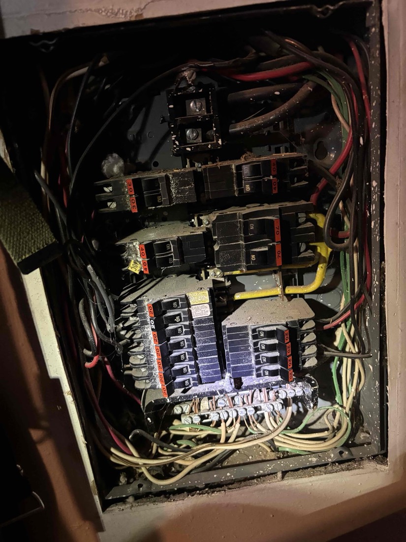 Neatly organized interior electrical panel with multiple breakers and color-coded wiring.
