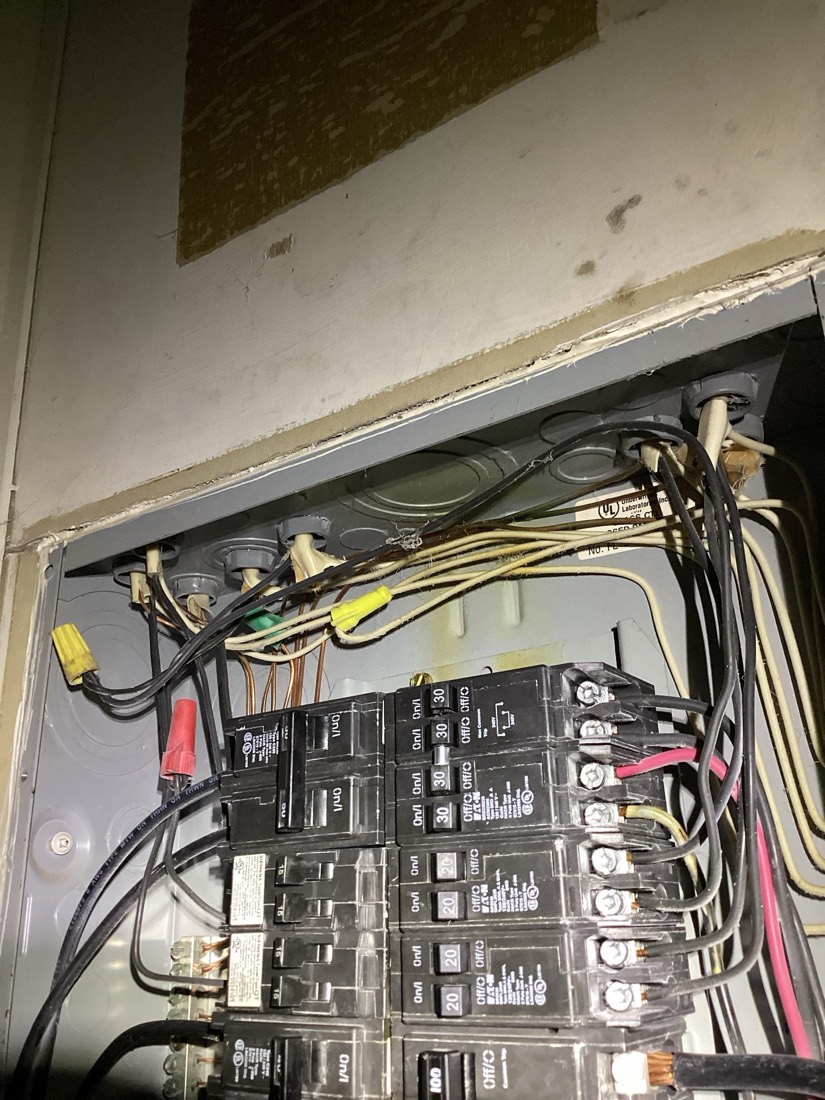 Electrical panel with multiple breakers and organized wiring connections.