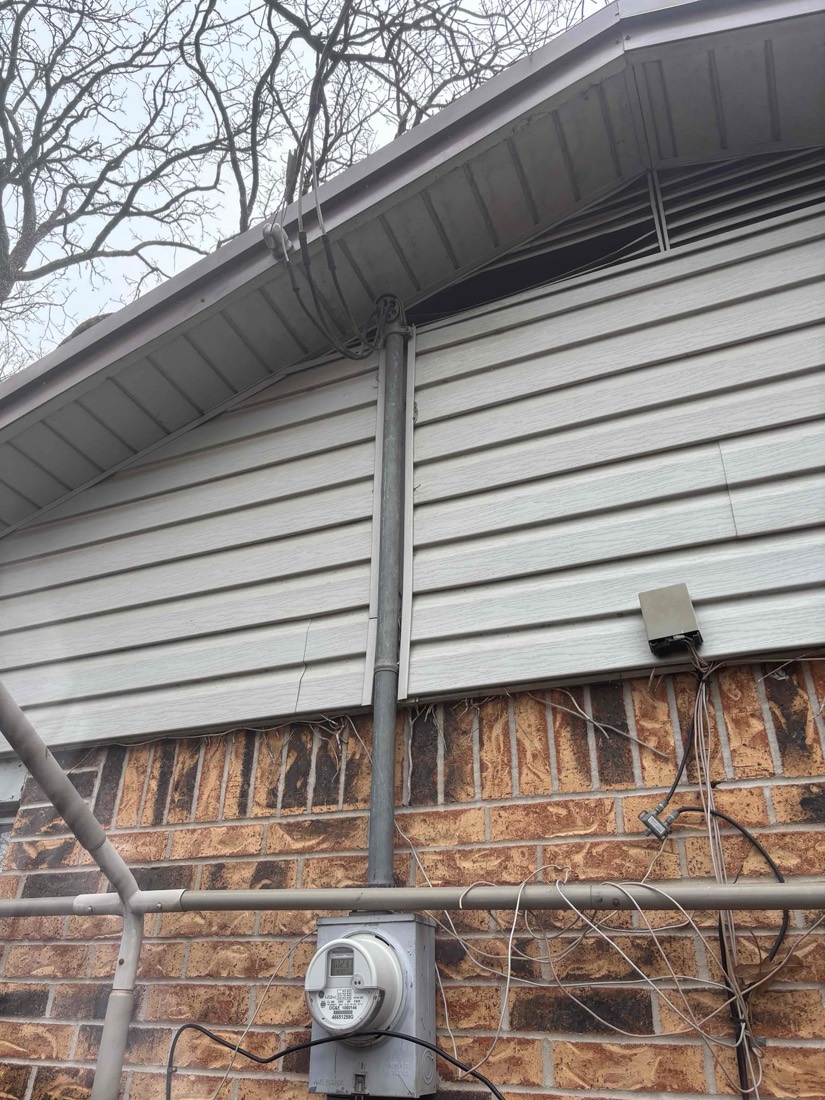 Electrical meter and wiring installed on brick home exterior