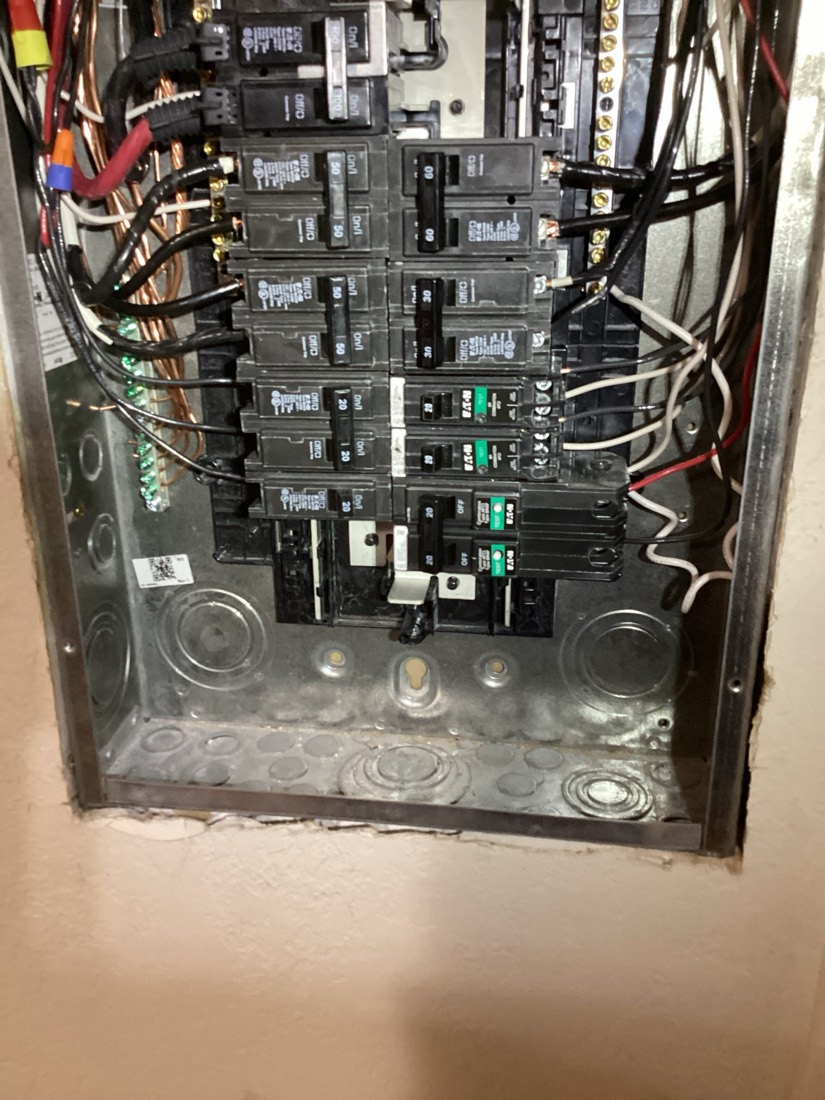 Electrical service panel with multiple circuit breakers and organized connections