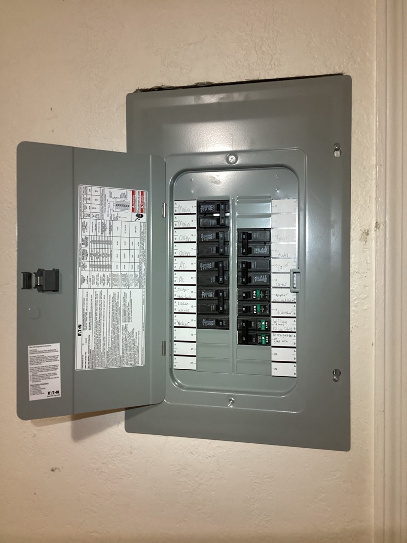 Gray electrical service panel with main breaker and circuit breakers installed