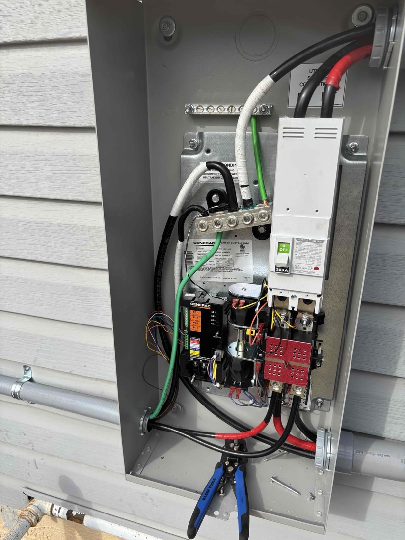 New electrical service panel with organized breakers, green and red wiring, mounted on exterior
