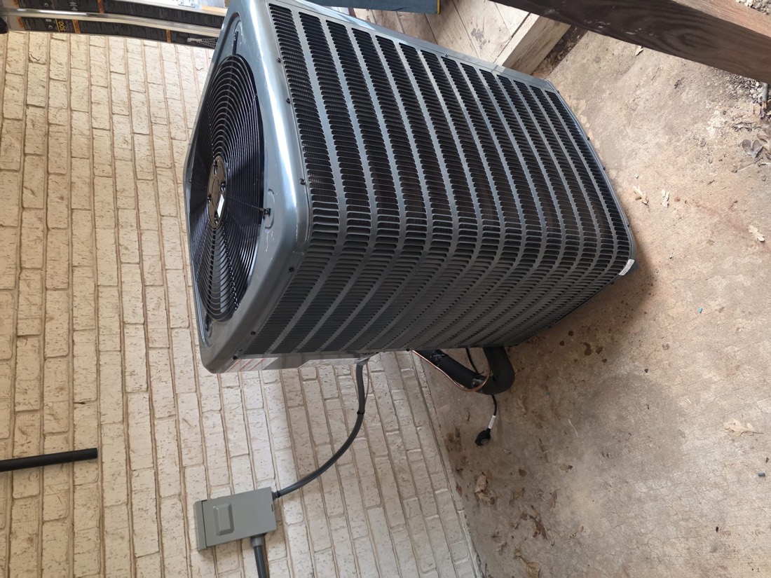 Installed AC condenser unit with power cord connected at outdoor location