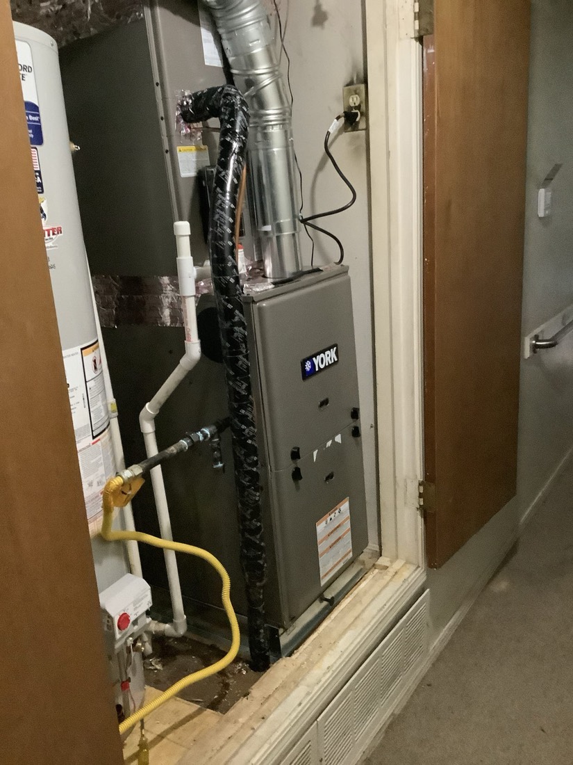 Installed York furnace with insulated black ductwork and copper refrigerant lines.