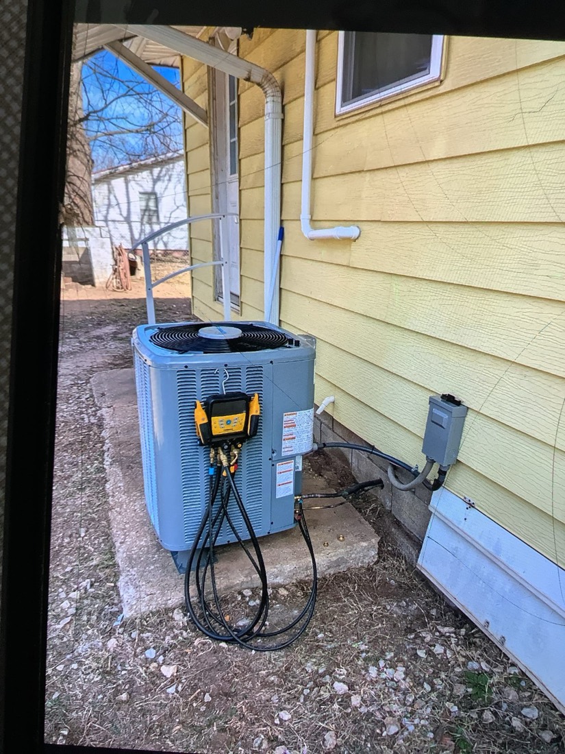 Installed Daikin heat pump outdoor unit with refrigerant lines.