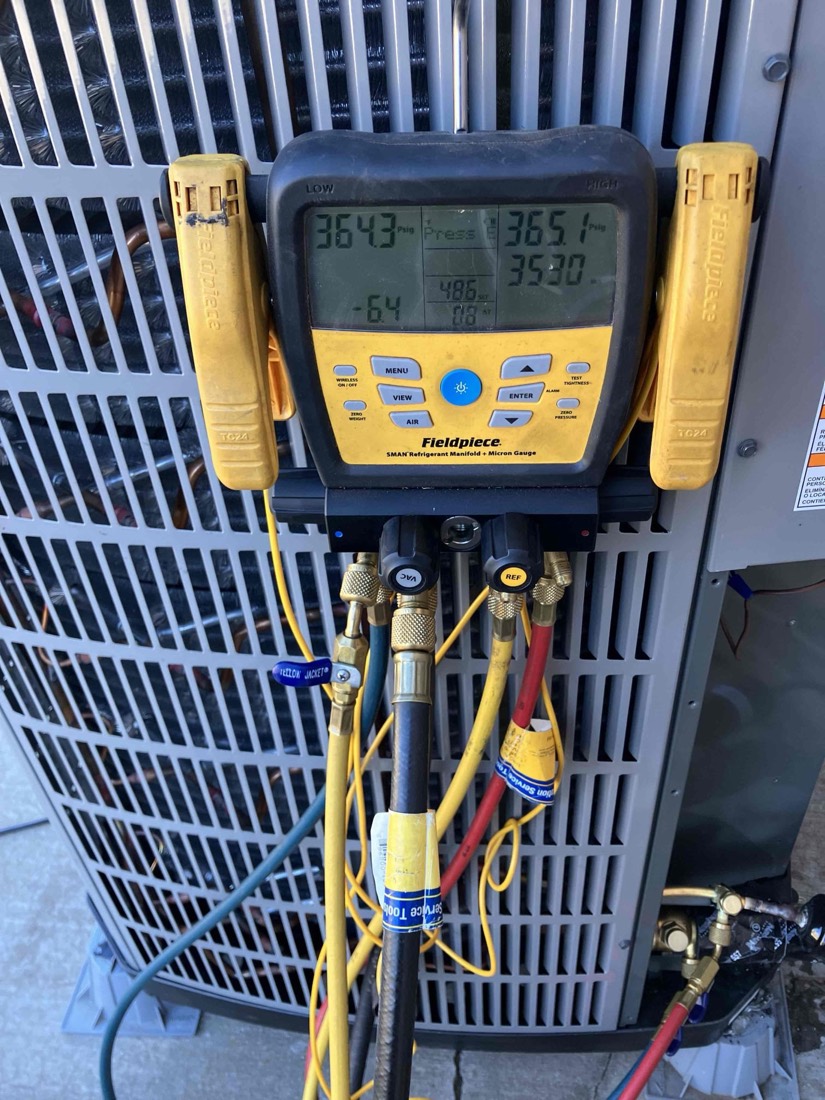 Fieldpiece digital manifold gauge measuring AC system pressure on new HVAC installation.
